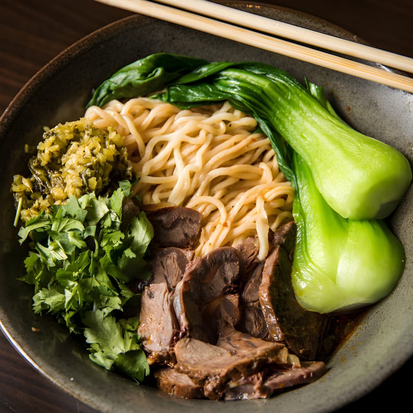 Xian Sushi and Noodle's beef noodle soup with bok choy, cilantro, and pickled vegetables.